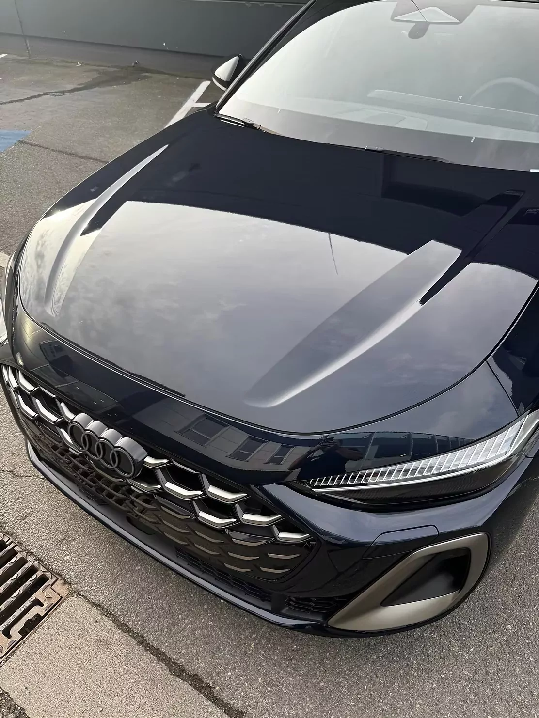 Capot d’Audi noire après correction de peinture, reflets nets