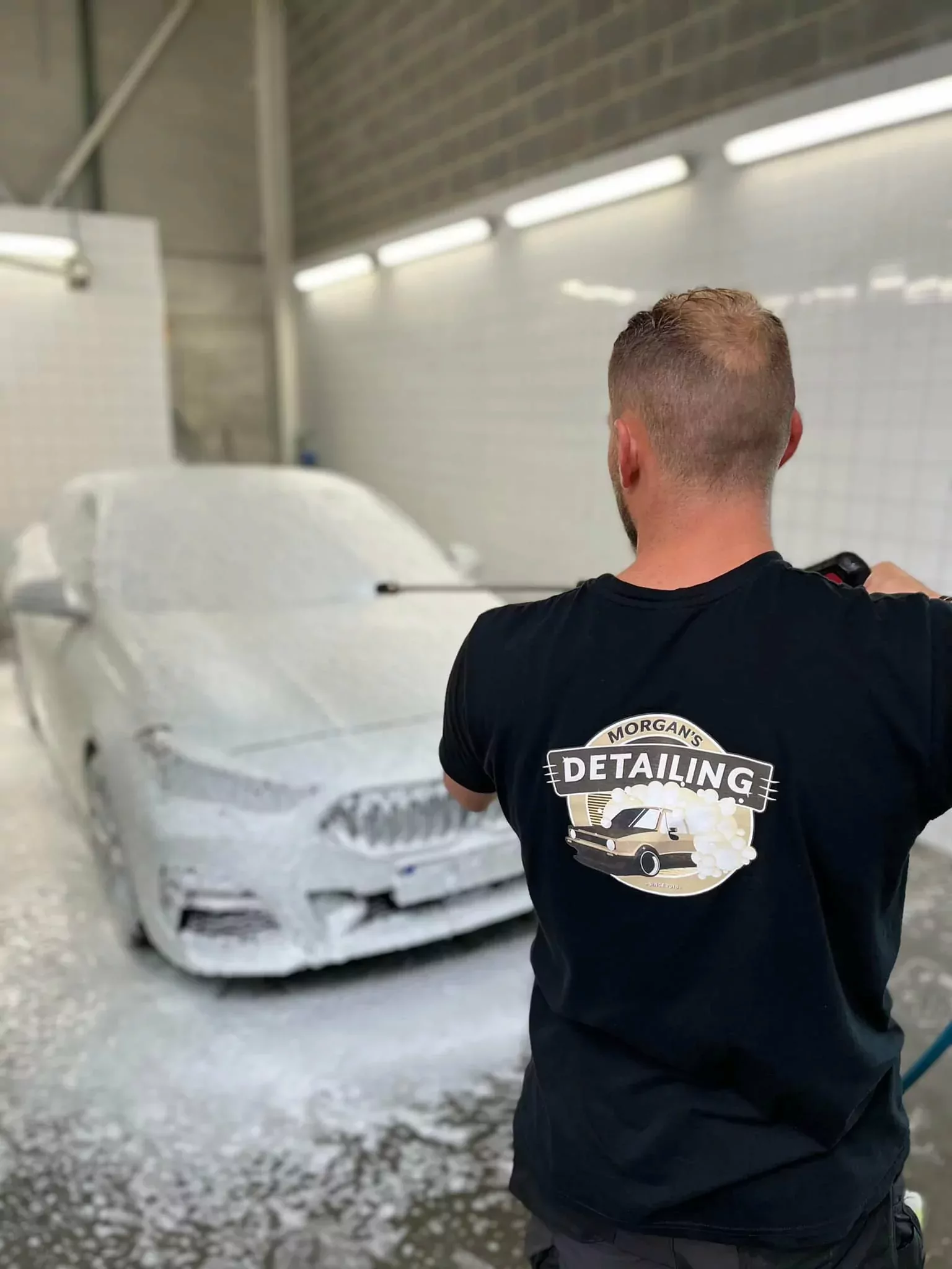Prélavage à la mousse active d’une berline, Morgan de dos