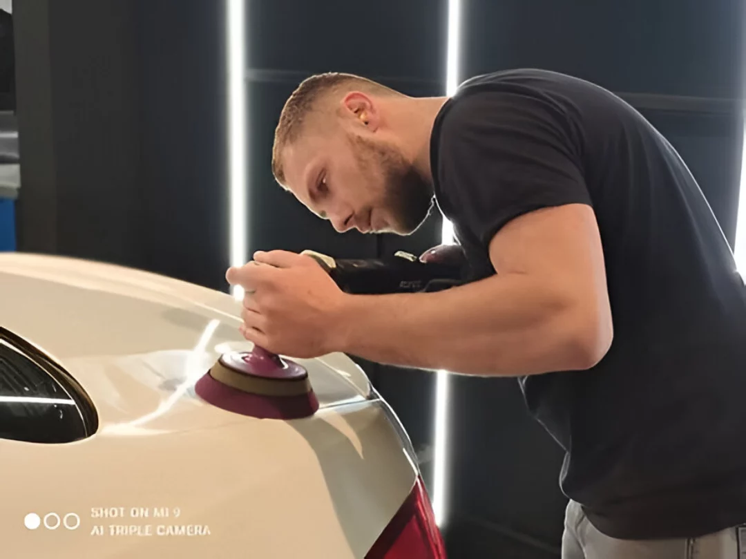 Polissage : polissage d’une carrosserie à la machine sous la lumière d’atelier