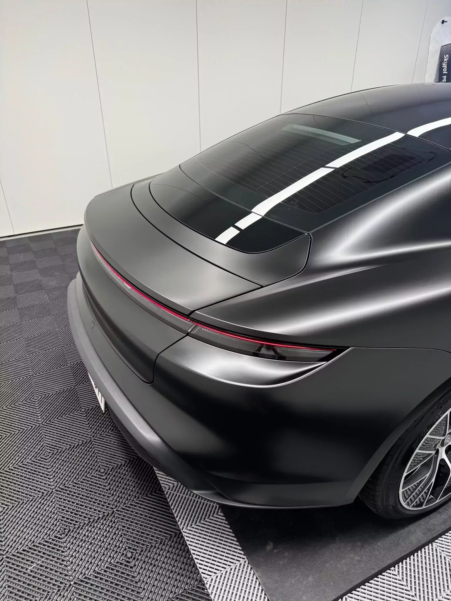 Porsche Taycan en covering satiné noir, arrière et bandeau lumineux