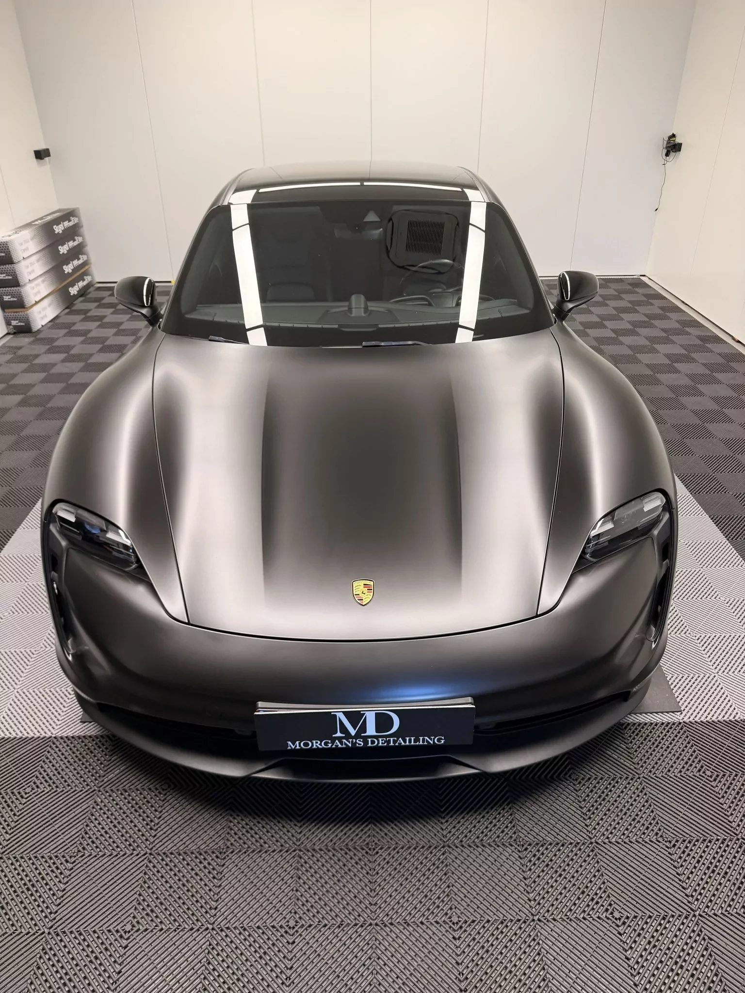 Porsche Taycan en covering satiné noir, face avant, plaque Morgan’s Detailing