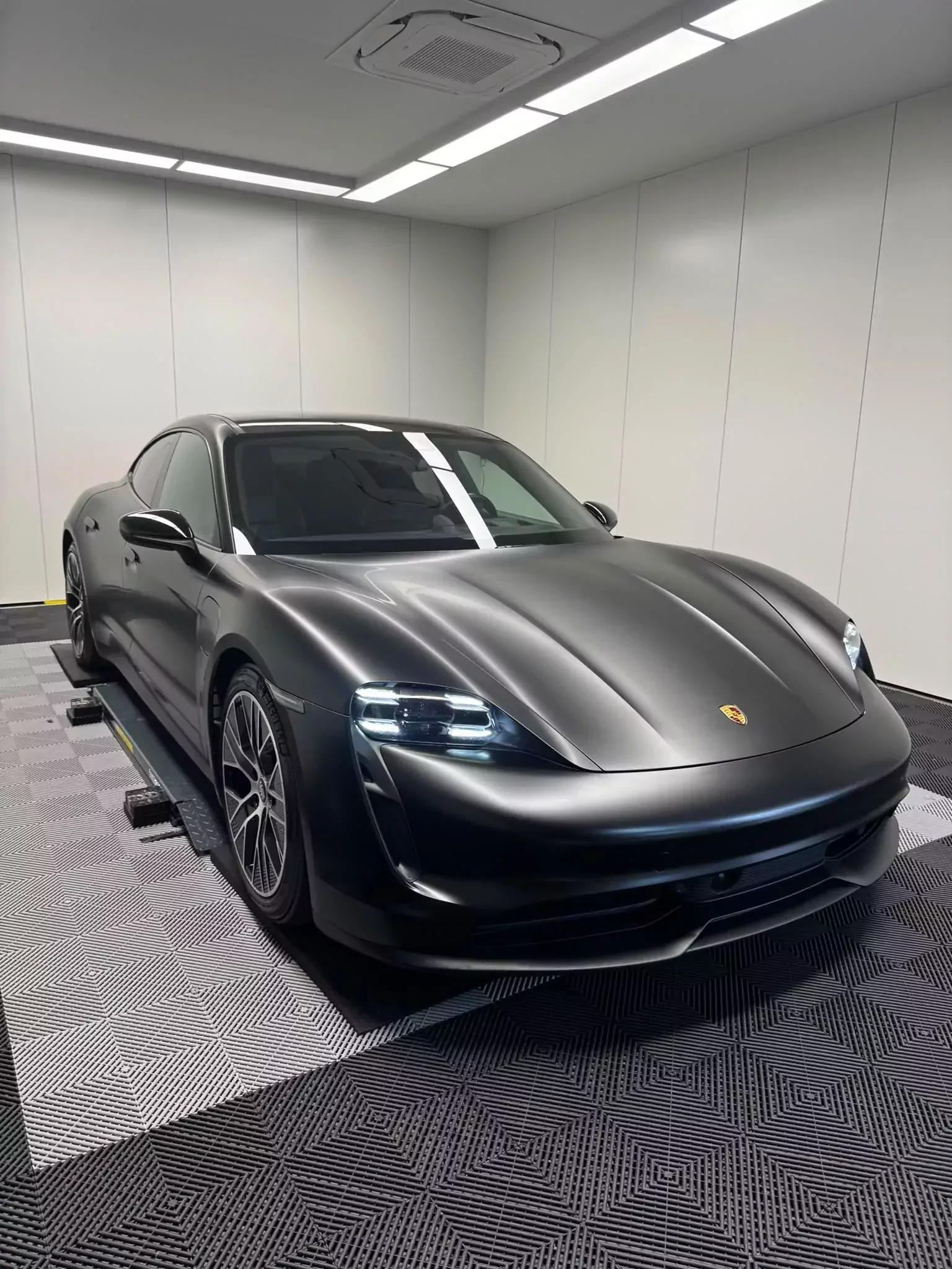 Porsche Taycan en covering satiné noir, trois quarts avant, atelier Morgan’s Detailing